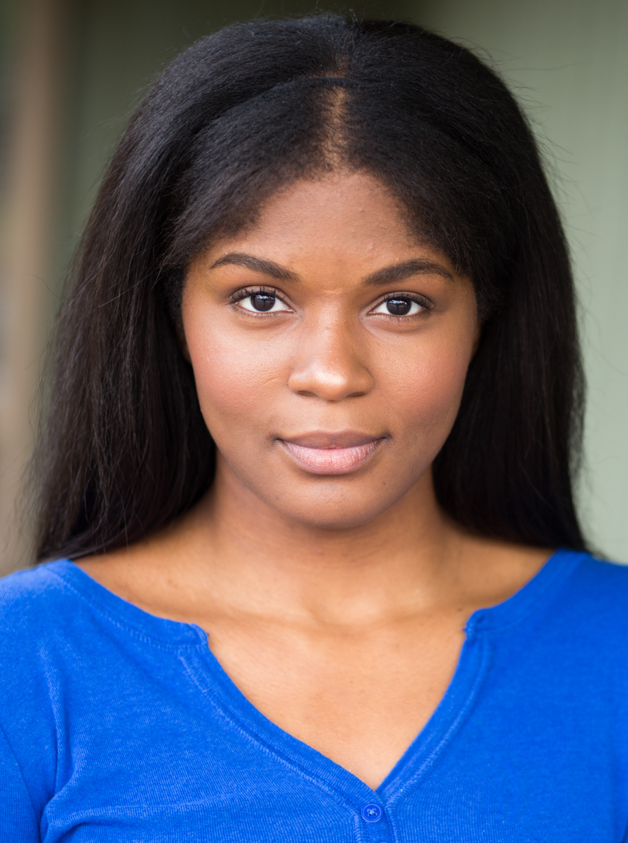 picture of black woman with long dark hair and wearing a blue shirt